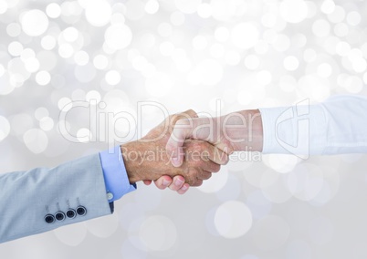 Hands shaking with sparkling light bokeh background