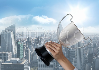 business hand with trophy in front of the city