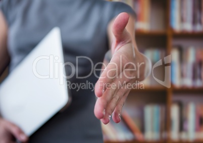 businesswoman giving hand with laptop in the other hand. Library