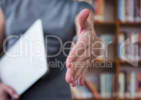 businesswoman giving hand with laptop in the other hand. Library