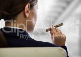 Over shoulder business woman smoking cigar against blurry grey stairs