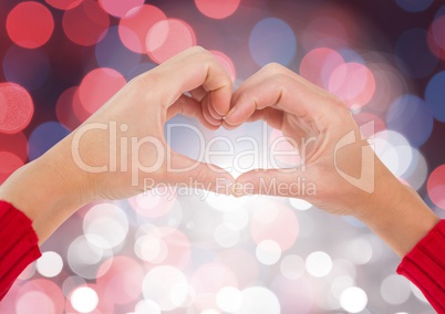 Hands in heart shape with sparkling light bokeh background