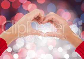 Hands in heart shape with sparkling light bokeh background