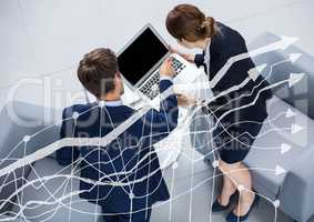 Overhead of business man and woman with laptop behind white graph