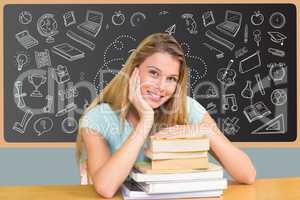 Girl student seated with books in front of black board with drawings