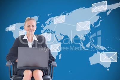 Businesswoman seated with a laptop in front of a digital world map