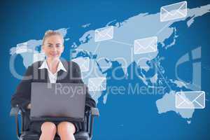 Businesswoman seated with a laptop in front of a digital world map