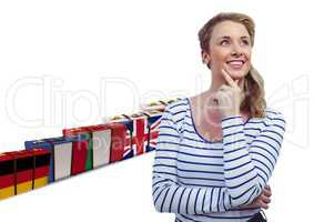 main language flag suitcases behin happy young woman thinking