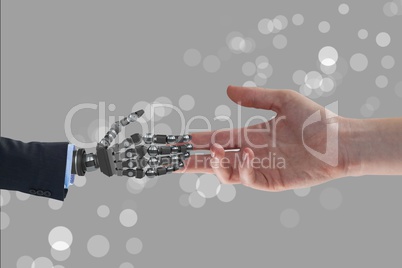 Human and robot handing their hands in grey background