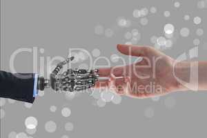 Human and robot handing their hands in grey background