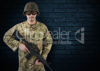 soldier with helmet, glasses and weapon. dark bricks background