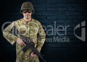soldier with helmet, glasses and weapon. dark bricks background
