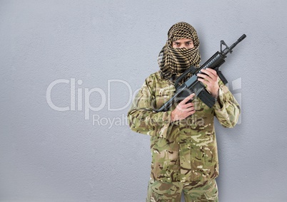 soldier with the face covered and weapon in the hands. concrete wall