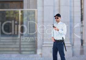 security guard with sun glasses and walkie-talkie guarding the door