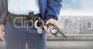 Security guard lower body with walkie talkie against skyline