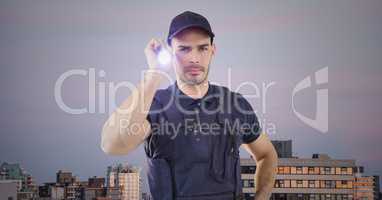Security guard with flashlight against buildings and purple sky