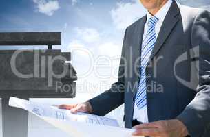 Architect holding a plan against the sky an a brigde
