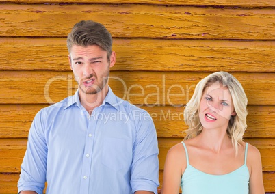 couple  funny faces with yellow wood background