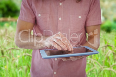 Model is touching tablet computer screen against outdoor background