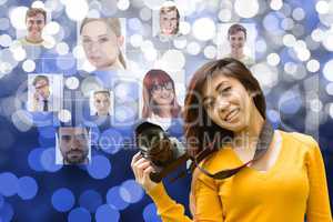 Young woman holding a camera in front of organization chart