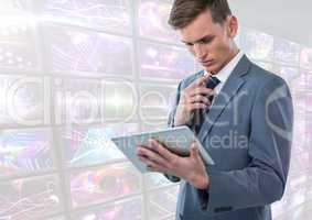 Businessman holding tablet with bright colorful screens visuals