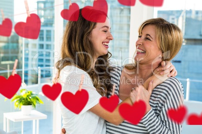 Mother and daughter laughing with drawings of heart