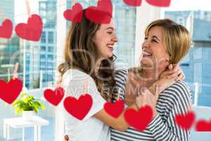 Mother and daughter laughing with drawings of heart