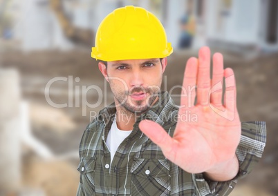 Construction Worker with stop hand gesture in front of construction site