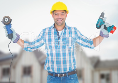 Construction Worker with drill in front of construction site