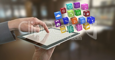 Businessman holding tablet with apps icons in office