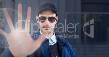 Security man outside blue background building with stop hand gesture