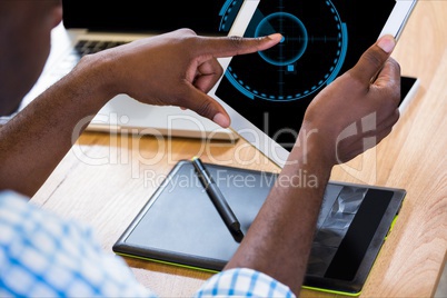 Businessman is touching his tablet computer screen against desk background