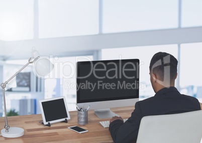 Businessman on computer in large bright office