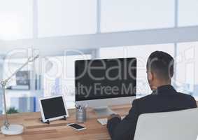 Businessman on computer in large bright office
