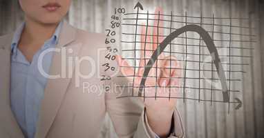 Business woman mid section touching brown graph with flare against blurry wood panel