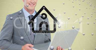 Businessman holding laptop with home symbol and connecting dots