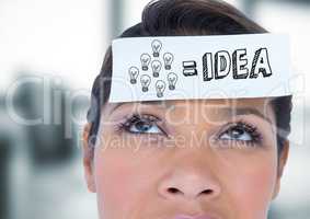 Close up of woman with card on head showing grey idea doodle in blurry grey office