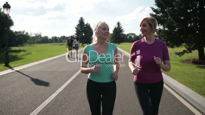 Adult female joggers pursuing activity outdoors