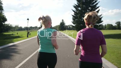 Back view of senior fitness women running on road