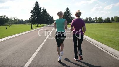 Back view of running women jogging in the park