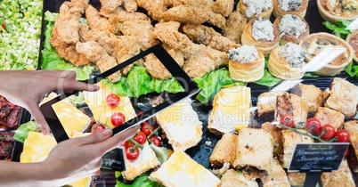 Hands taking picture of food through digital tablet