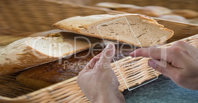 Cropped hands taking picture of bread through transparent device at cafe