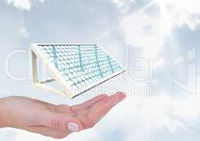 Digital image of hand with solar panel against sky