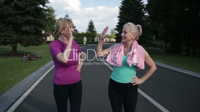 Running females giving high five after training