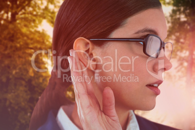 Composite image of businesswoman trying to listen