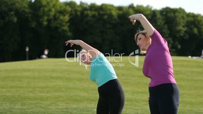 Sporty women doing stretching exercises in park
