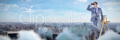 Composite image of happy businessman using binoculars while standing on ladder