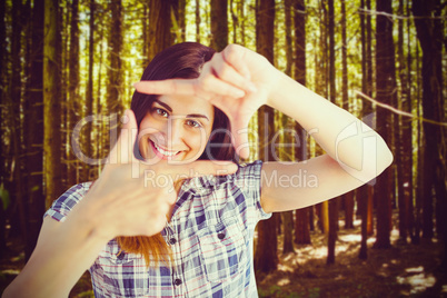 Composite image of portrait of woman looking through hands
