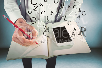 Composite image of man with mobile phone writing on book