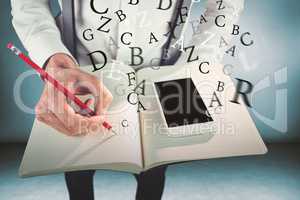 Composite image of man with mobile phone writing on book